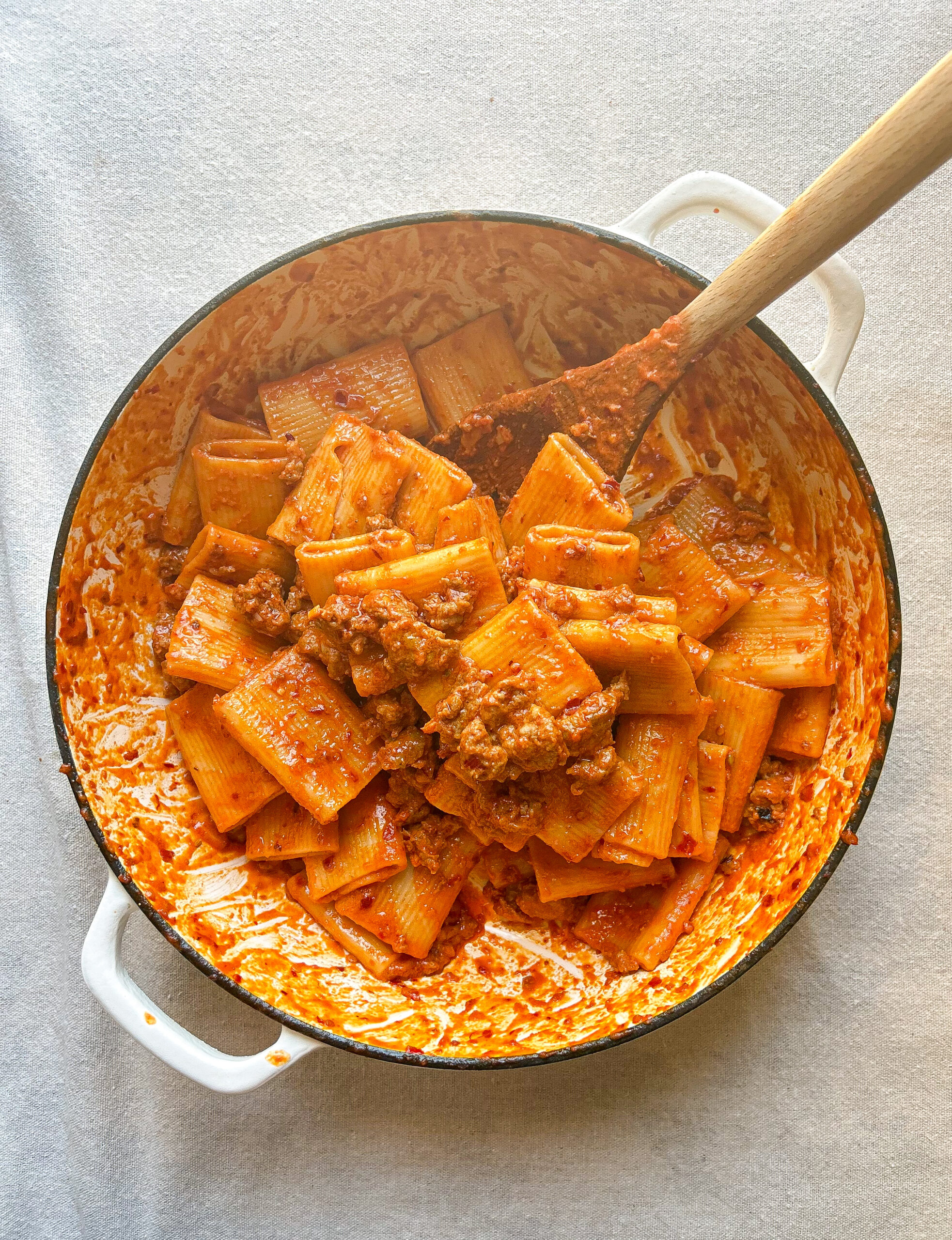 creamy nduja pasta sits in a white pot after being tossed
