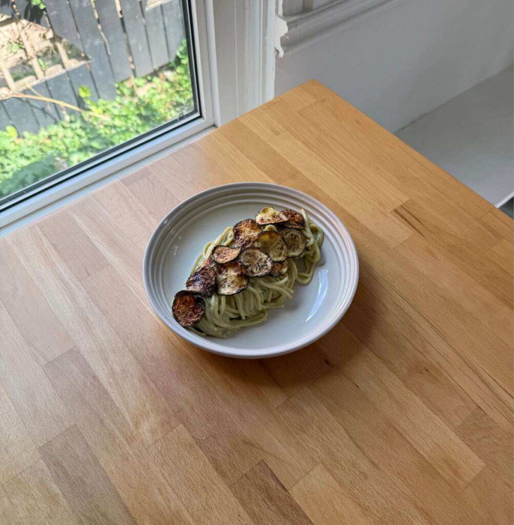 Zucchini Cream Pasta in a white bowl sitting on the counter top