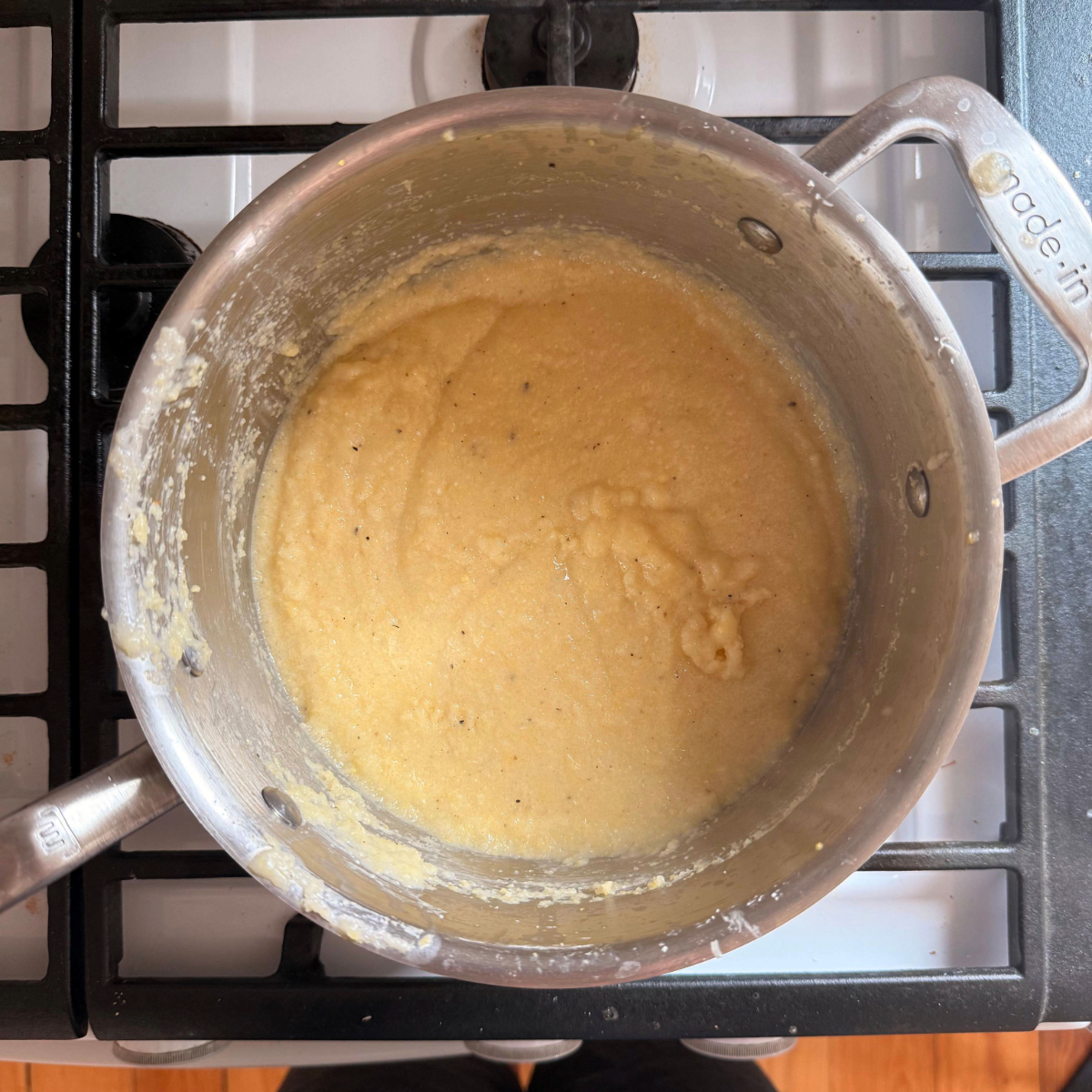 creamy polenta made with corncobs, mascarpone and parmesan in a pot on the stove