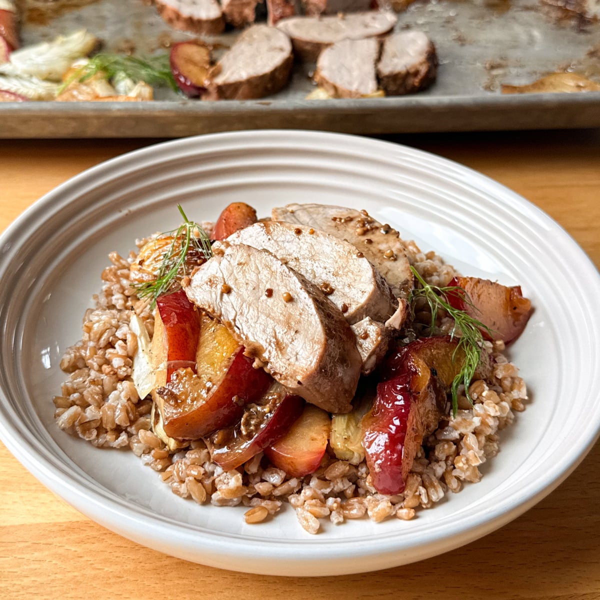 Serve baked pork tenderloin with farro and roasted plums and fennel